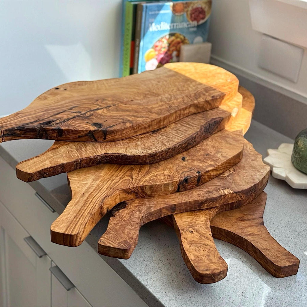 Behold the beauty of our handmade olive wood charcuterie board collection. Each piece showcases the unique, organic grain of premium olive wood, creating a naturally stunning centerpiece for your kitchen or dining space. These aren&#39;t just serving boards; they are works of art, perfect for displaying delectable charcuterie, cheeses, and appetizers, adding a touch of rustic elegance to any gathering. Also makes a thoughtful and unique gift for those who appreciate the natural beauty of olive w
