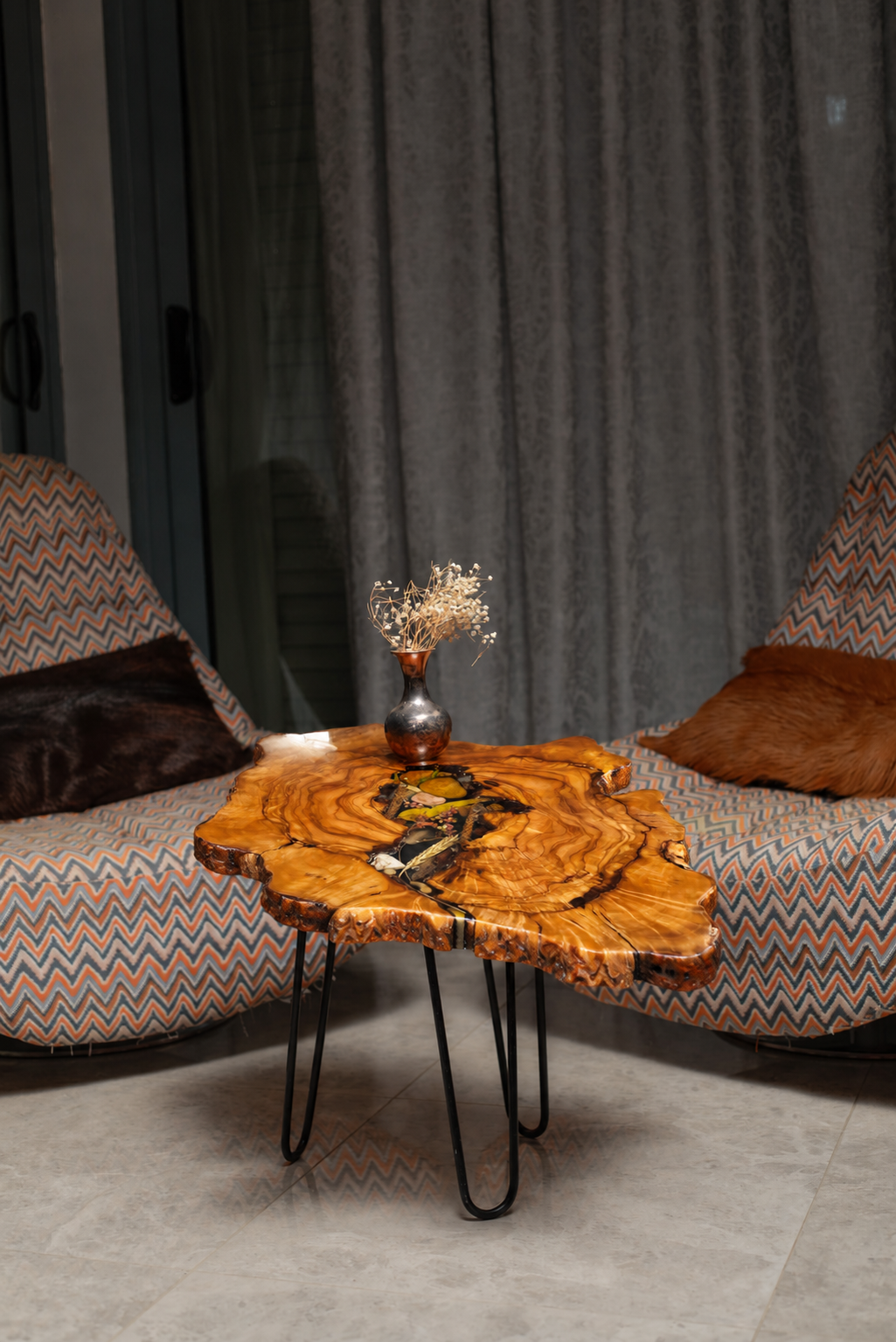AI-styled view of Zitun Atelier table 003, an olive wood resin side table with black resin dried flowers, in a lounge setting with a vase on the tabletop.