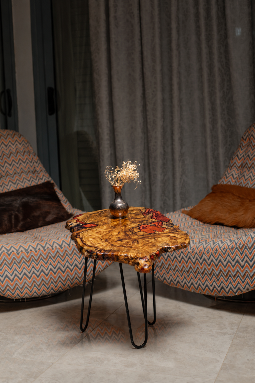 AI-styled view of Zitun Atelier table 005, an olive wood resin side table with red resin burl, in a lounge setting with a vase on the tabletop.