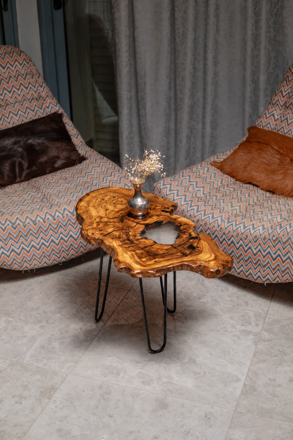 AI-styled view of Zitun Atelier table 006, an olive wood resin side table with white resin center, viewed from above between two upholstered armchairs.