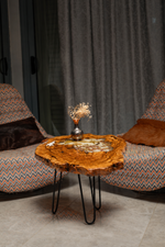 AI-styled view of Zitun Atelier table 007, an olive wood resin side table with white resin dried flowers, in a lounge setting with a vase on the tabletop.