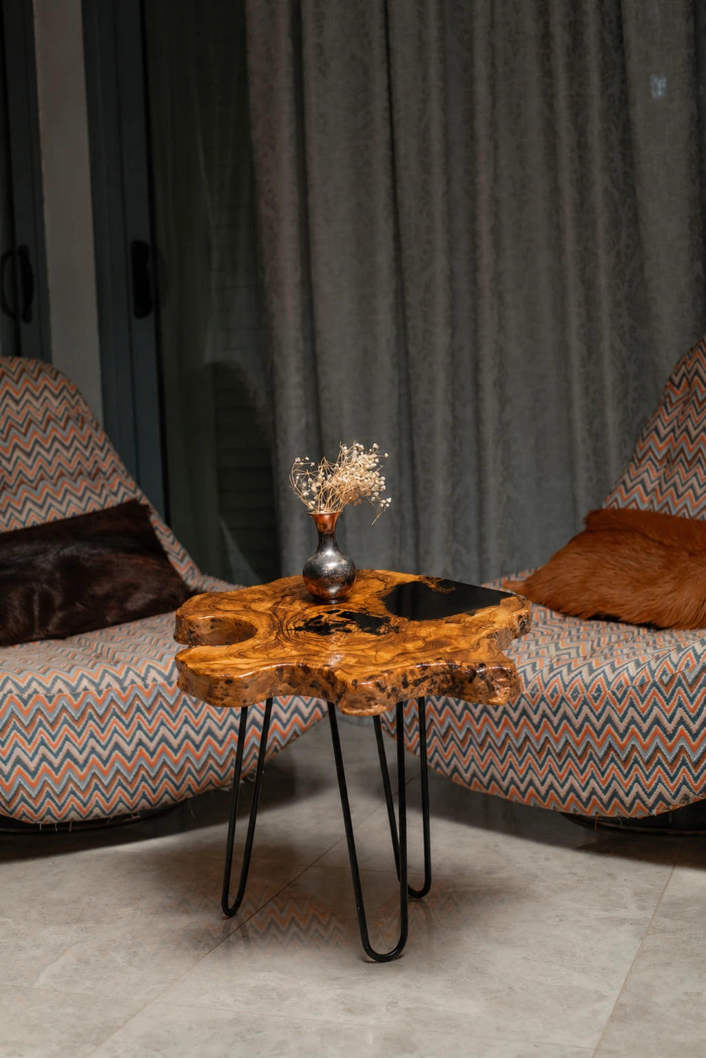AI-styled view of Zitun Atelier table 009, an olive wood resin side table with black resin pour, in a lounge setting with a vase on the tabletop.