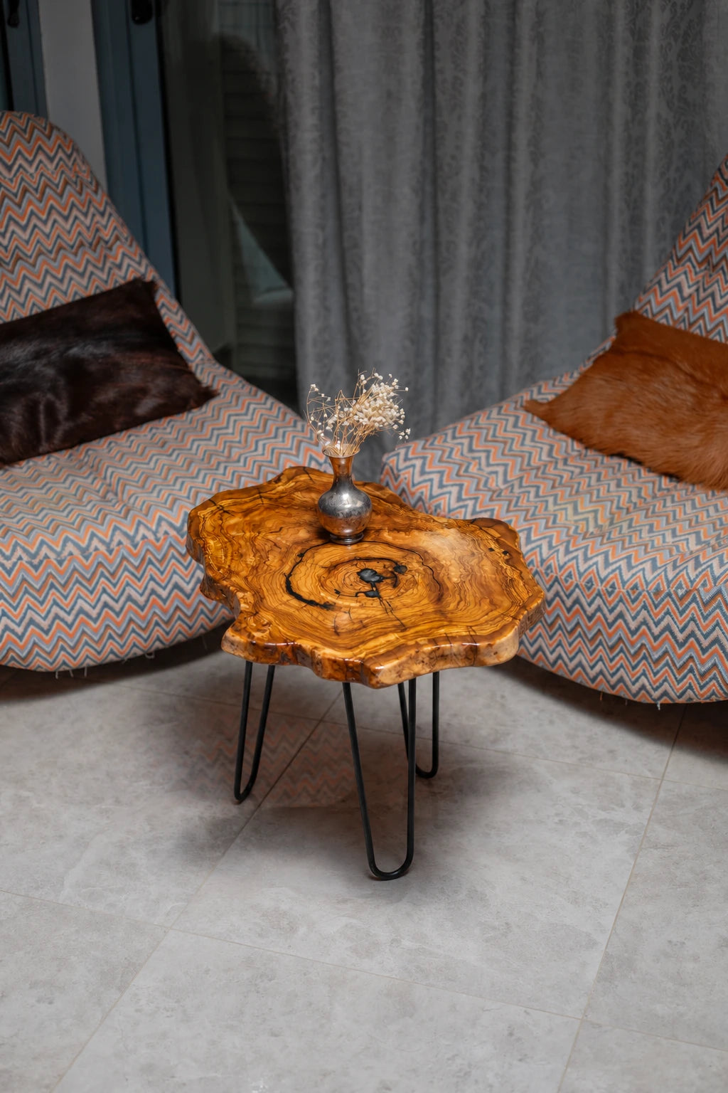 AI-styled view of Zitun Atelier table 010, an olive wood resin side table with black resin ring, viewed from above between two upholstered armchairs.