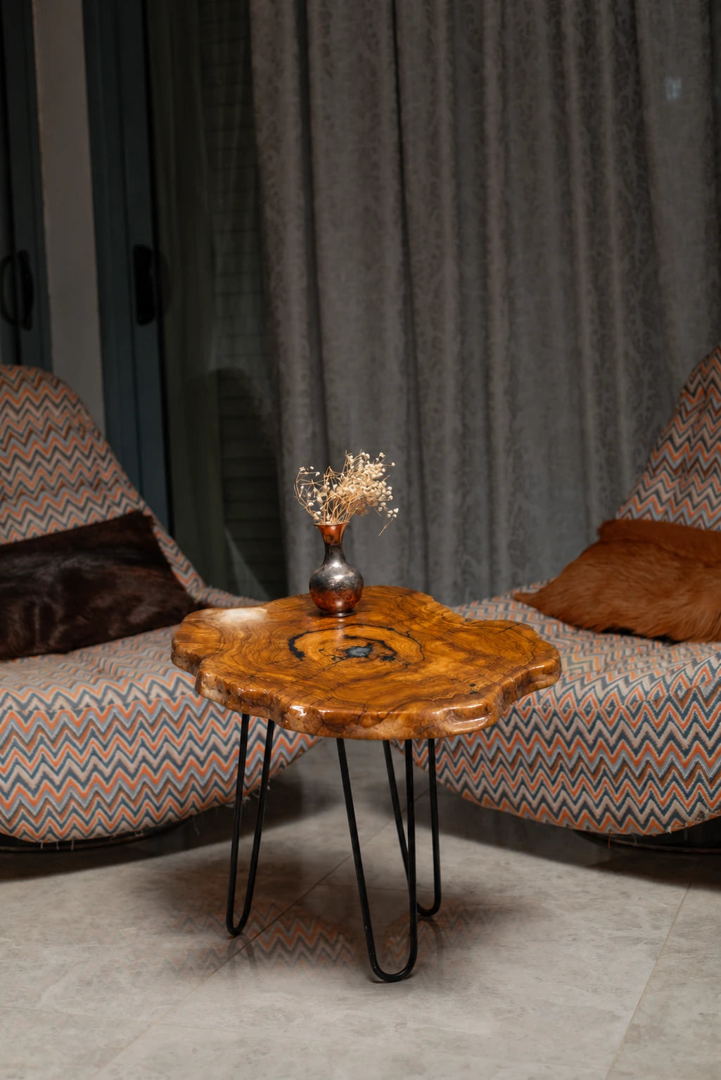 AI-styled view of Zitun Atelier table 010, an olive wood resin side table with black resin ring, in a lounge setting with a vase on the tabletop.