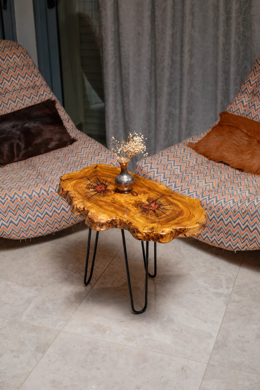 AI-styled view of Zitun Atelier table 011, an olive wood resin side table with red resin accents, viewed from above between two upholstered armchairs.