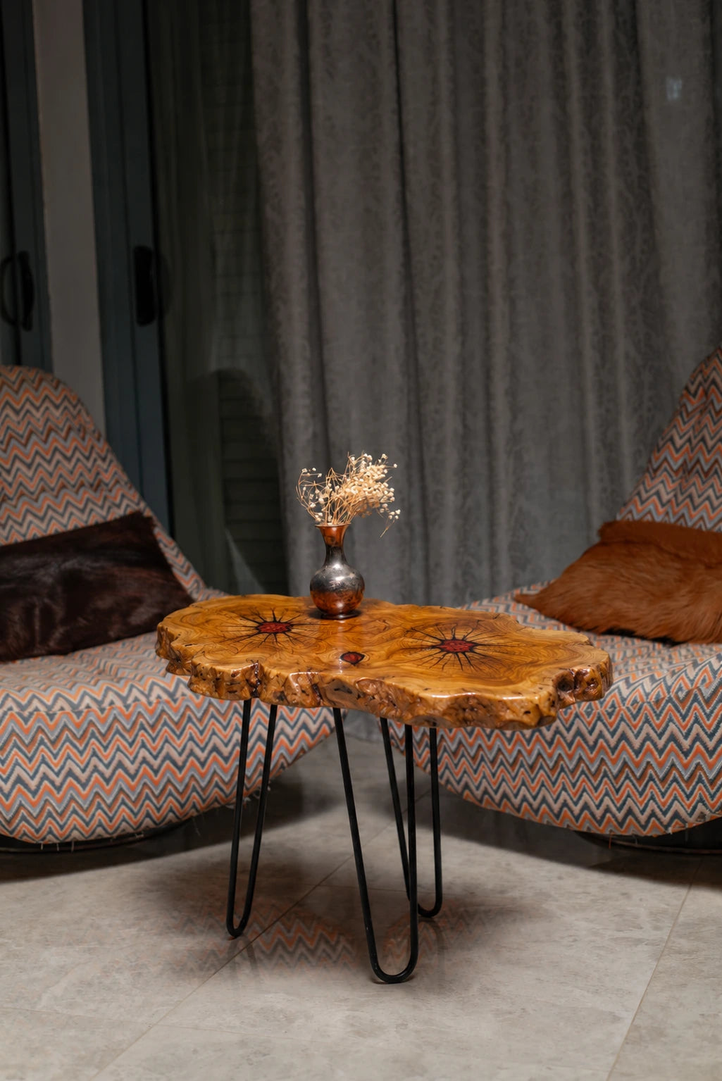 AI-styled view of Zitun Atelier table 011, an olive wood resin side table with red resin accents, in a lounge setting with a vase on the tabletop.
