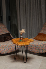 AI-styled view of Zitun Atelier table 012, an olive wood resin side table with emerald green star resin, in a lounge setting with a vase on the tabletop.