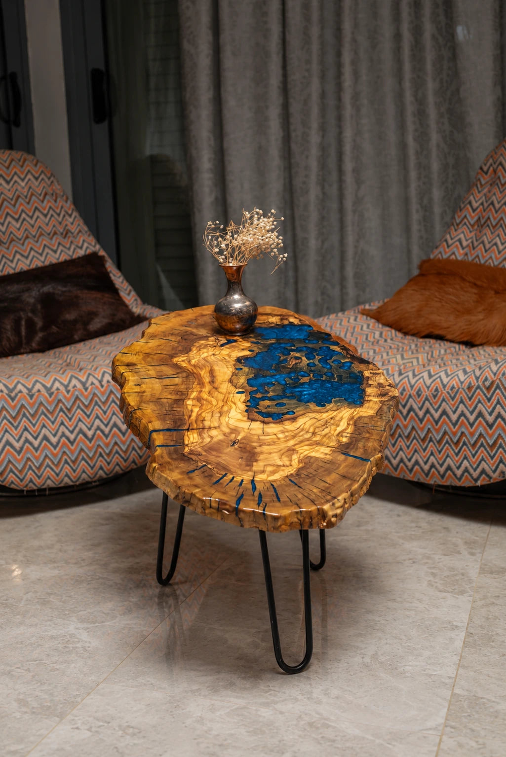 AI-styled view of Zitun Atelier table 017, an olive wood resin small coffee table with blue resin pool, in a lounge setting with a vase on the tabletop.