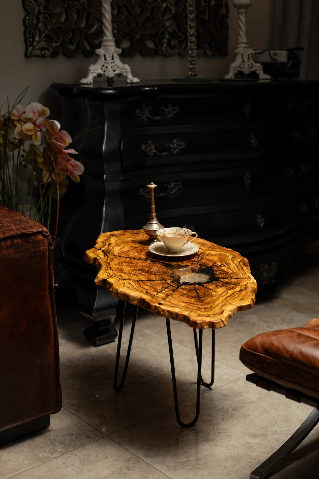 AI-styled view of Zitun Atelier table 018, an olive wood resin small coffee table with white resin center, in a dark interior beside leather seating.