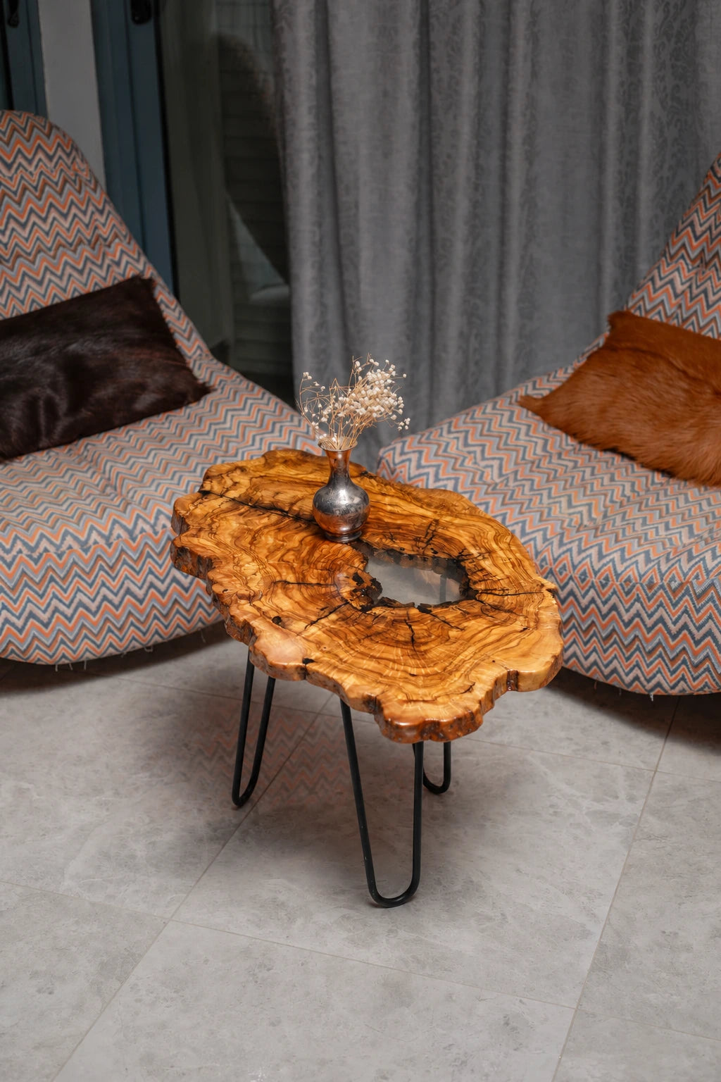 AI-styled view of Zitun Atelier table 018, an olive wood resin small coffee table with white resin center, viewed from above between two upholstered armchairs.