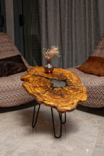 AI-styled view of Zitun Atelier table 018, an olive wood resin small coffee table with white resin center, in a lounge setting with a vase on the tabletop.