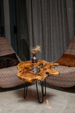 AI-styled view of Zitun Atelier table 019, an olive wood resin side table with white resin center, in a lounge setting with a vase on the tabletop.