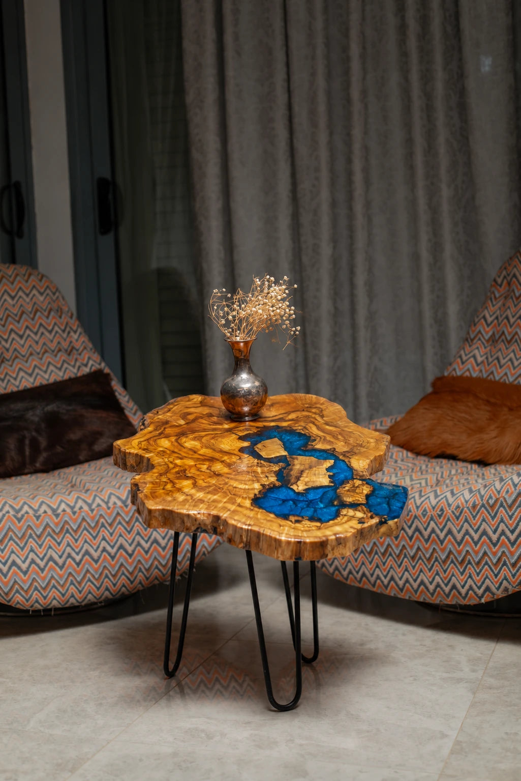 AI-styled view of Zitun Atelier table 020, an olive wood resin side table with electric blue resin river, in a lounge setting with a vase on the tabletop.
