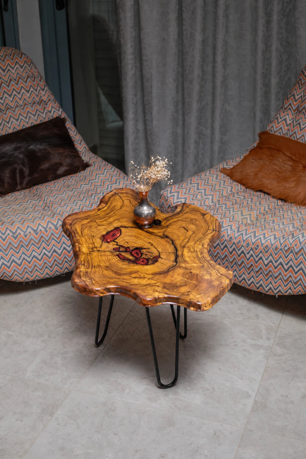 AI-styled view of Zitun Atelier table 023, an olive wood resin side table with copper red resin inlay, viewed from above between two upholstered armchairs.