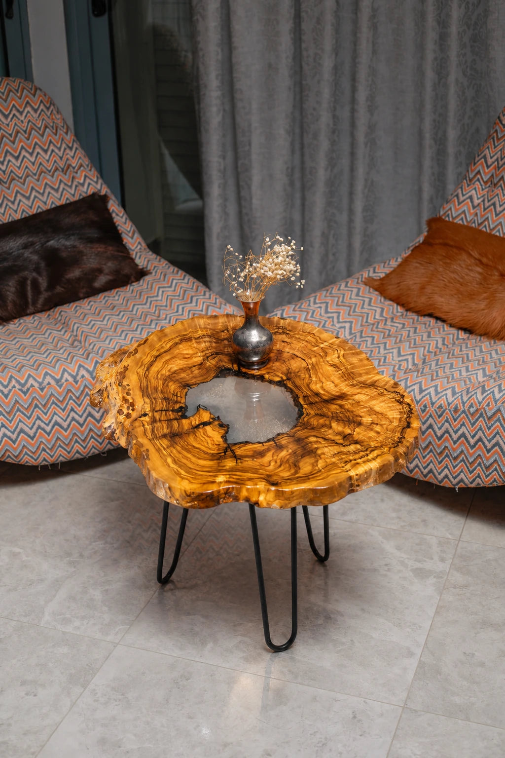 AI-styled view of Zitun Atelier table 025, an olive wood resin side table with white resin center, viewed from above between two upholstered armchairs.