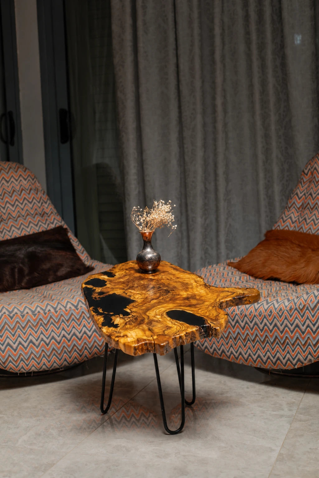 AI-styled view of Zitun Atelier table 027, an olive wood resin side table with black resin live edge, in a lounge setting with a vase on the tabletop.