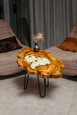 AI-styled view of Zitun Atelier table 028, an olive wood resin side table with white resin nautical charms, in a lounge setting with a vase on the tabletop.