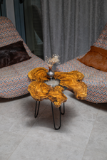 AI-styled view of Zitun Atelier table 029, an olive wood resin side table with white resin center, viewed from above between two upholstered armchairs.
