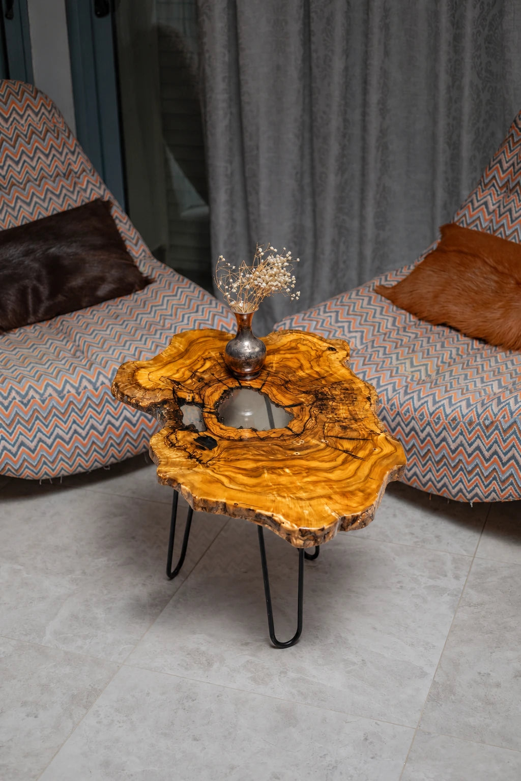 AI-styled view of Zitun Atelier table 030, an olive wood resin side table with white resin center, viewed from above between two upholstered armchairs.