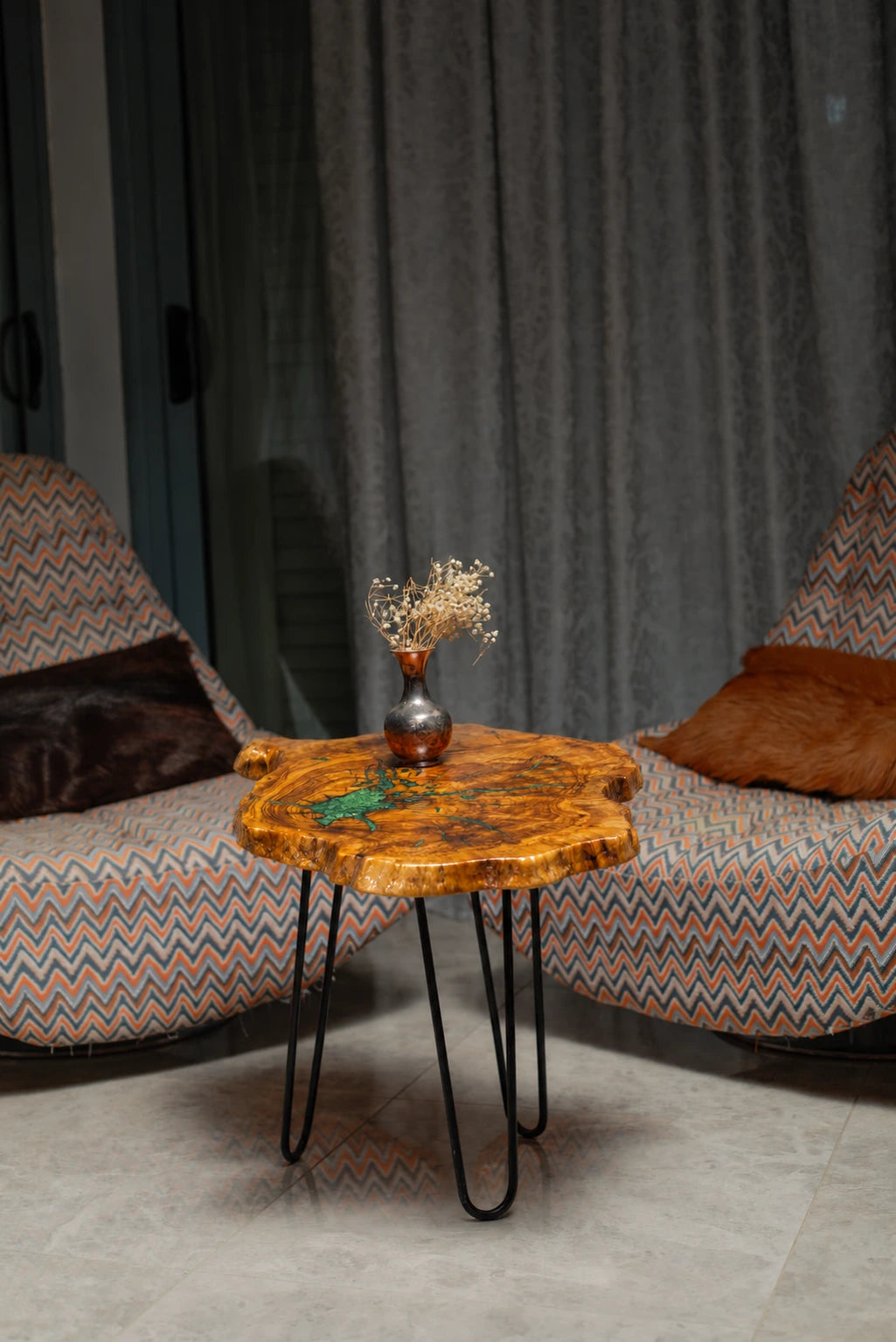 AI-styled view of Zitun Atelier table 031, an olive wood resin side table with emerald green resin veins, in a lounge setting with a vase on the tabletop.