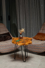 AI-styled view of Zitun Atelier table 031, an olive wood resin side table with emerald green resin veins, in a lounge setting with a vase on the tabletop.