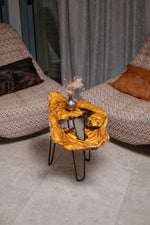 AI-styled view of Zitun Atelier table 032, an olive wood resin side table with white black resin center, viewed from above between two upholstered armchairs.