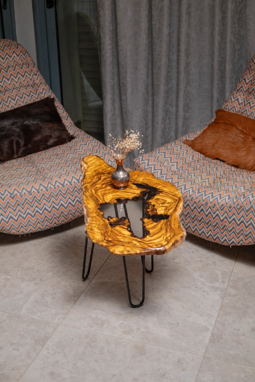 AI-styled view of Zitun Atelier table 032, an olive wood resin side table with white black resin center, viewed from above between two upholstered armchairs.