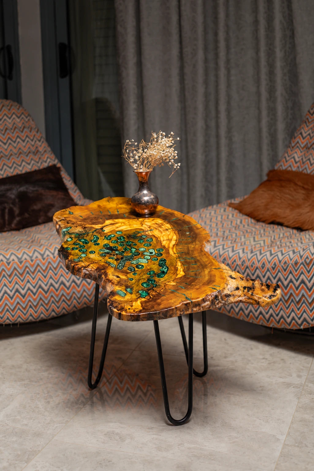 AI-styled view of Zitun Atelier table 033, an olive wood resin side table with green malachite resin, in a lounge setting with a vase on the tabletop.