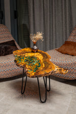 AI-styled view of Zitun Atelier table 033, an olive wood resin side table with green malachite resin, in a lounge setting with a vase on the tabletop.