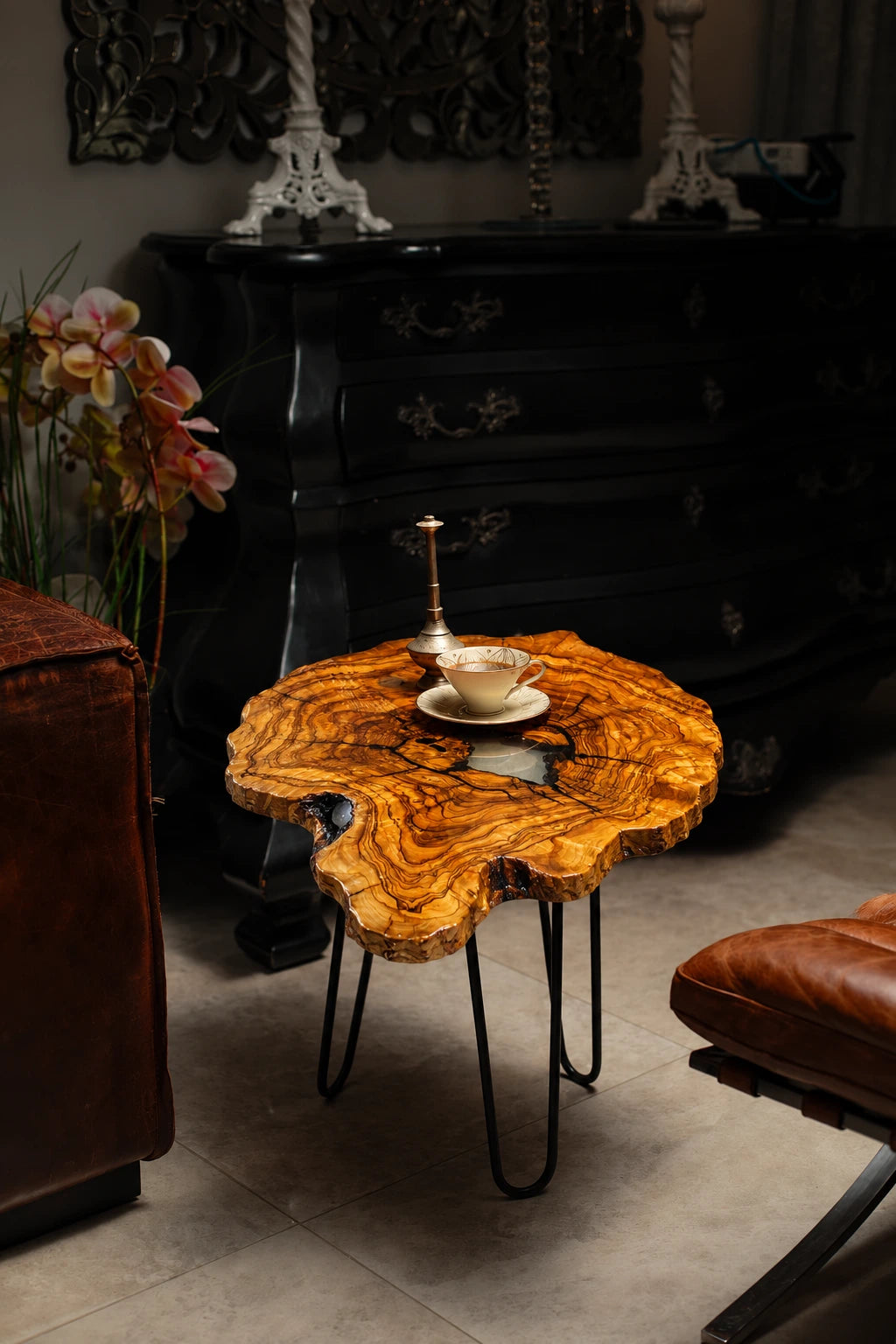 AI-styled view of Zitun Atelier table 035, an olive wood resin side table with white resin center, in a dark interior beside leather seating.