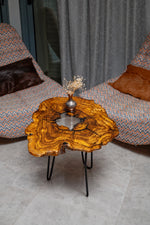 AI-styled view of Zitun Atelier table 041, an olive wood resin side table with white resin center, viewed from above between two upholstered armchairs.