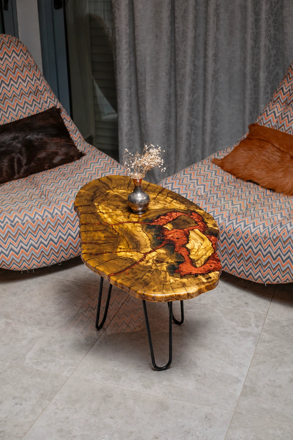 AI-styled view of Zitun Atelier table 042, an olive wood resin side table with red coral resin, viewed from above between two upholstered armchairs.