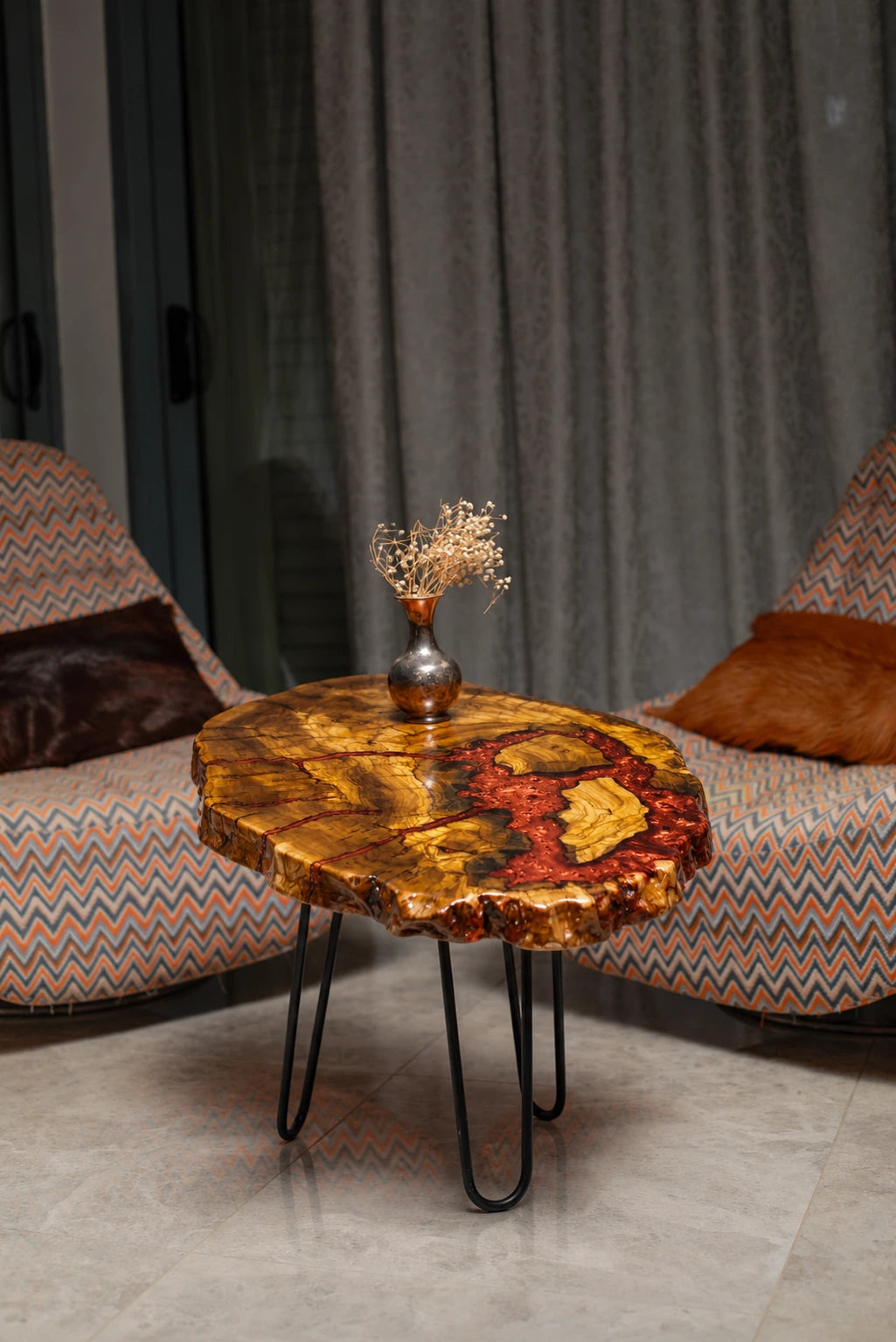 AI-styled view of Zitun Atelier table 042, an olive wood resin side table with red coral resin, in a lounge setting with a vase on the tabletop.