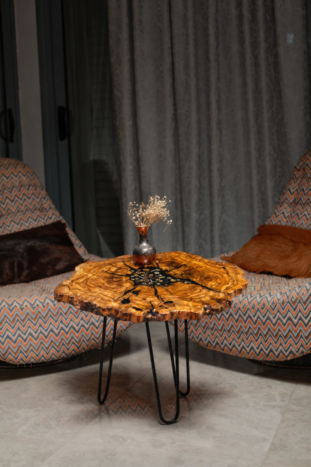 AI-styled view of Zitun Atelier table 055, an olive wood resin small coffee table with black resin clock gears, in a lounge setting with a vase on the tabletop.