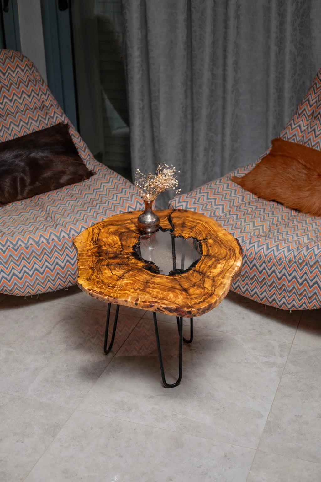 AI-styled view of Zitun Atelier table 058, an olive wood resin side table with white resin center, viewed from above between two upholstered armchairs.