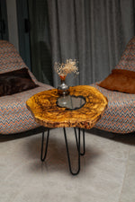AI-styled view of Zitun Atelier table 058, an olive wood resin side table with white resin center, in a lounge setting with a vase on the tabletop.