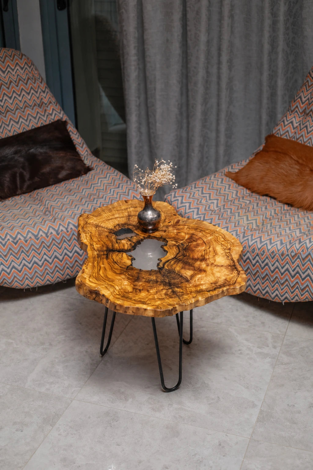 AI-styled view of Zitun Atelier table 059, an olive wood resin side table with white resin center, viewed from above between two upholstered armchairs.