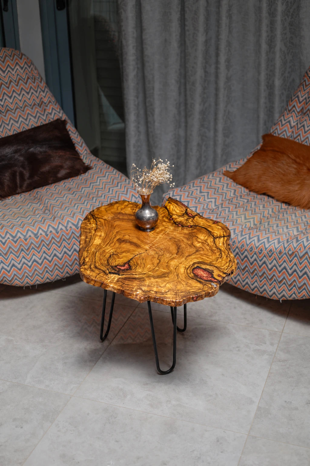AI-styled view of Zitun Atelier table 061, an olive wood resin side table with copper resin inlay, viewed from above between two upholstered armchairs.