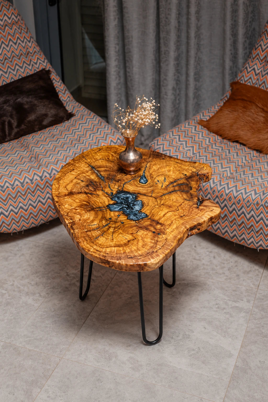 AI-styled view of Zitun Atelier table 064, an olive wood resin side table with metallic blue resin, viewed from above between two upholstered armchairs.