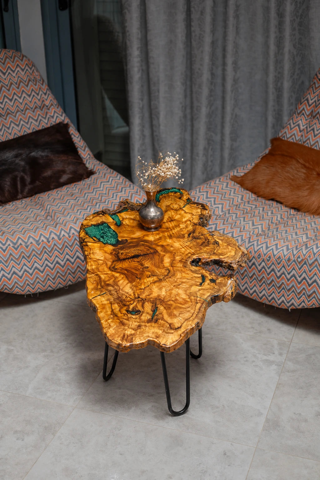 AI-styled view of Zitun Atelier table 068, an olive wood resin small coffee table with emerald green resin edge, viewed from above between two upholstered armchairs.