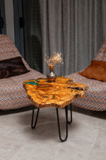 AI-styled view of Zitun Atelier table 068, an olive wood resin small coffee table with emerald green resin edge, in a lounge setting with a vase on the tabletop.