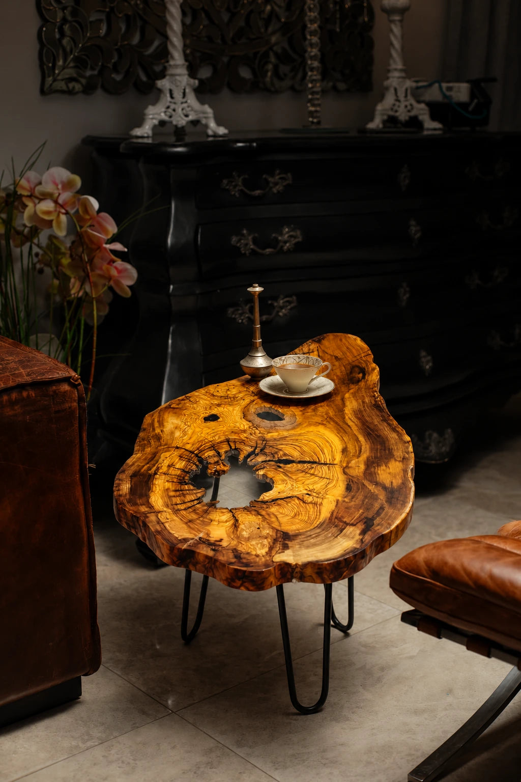 AI-styled view of Zitun Atelier table 069, an olive wood resin side table with white resin center, in a dark interior beside leather seating.