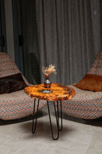 AI-styled view of Zitun Atelier table 069, an olive wood resin side table with white resin center, in a lounge setting with a vase on the tabletop.