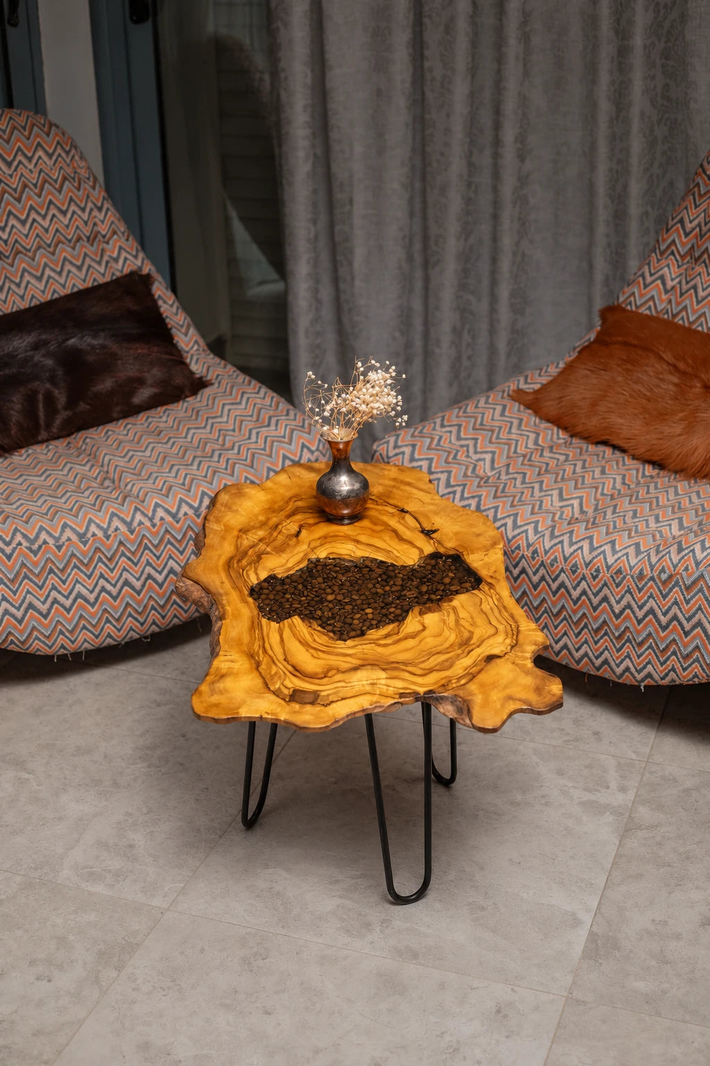 AI-styled view of Zitun Atelier table 070, an olive wood resin side table with coffee bean resin, viewed from above between two upholstered armchairs.