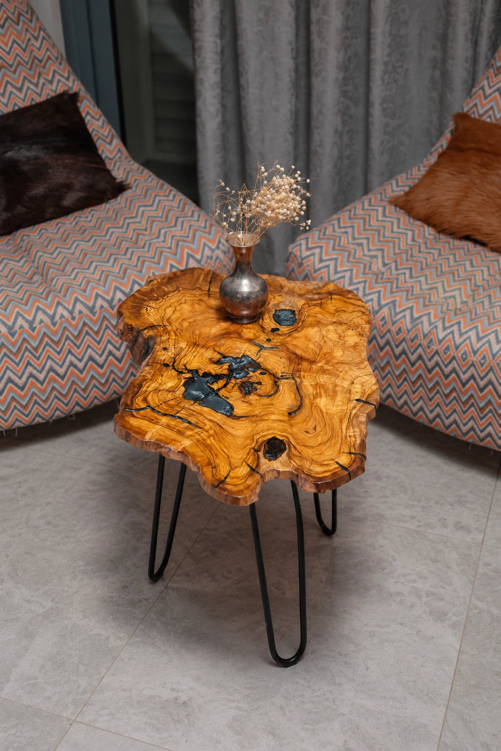 AI-styled view of Zitun Atelier table 071, an olive wood resin side table with blue resin veins, viewed from above between two upholstered armchairs.