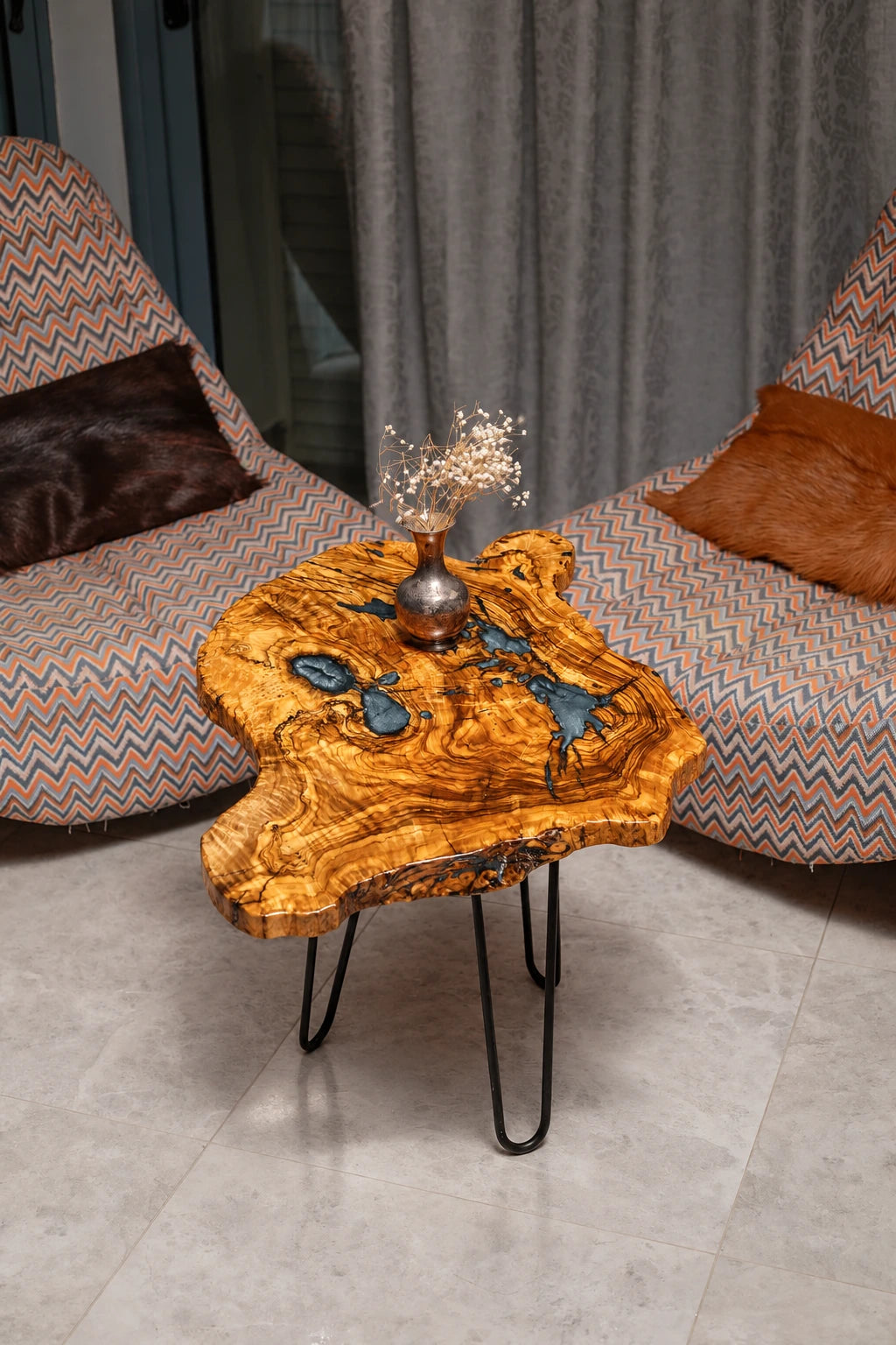 AI-styled view of Zitun Atelier table 073, an olive wood resin small coffee table with blue grey resin, viewed from above between two upholstered armchairs.