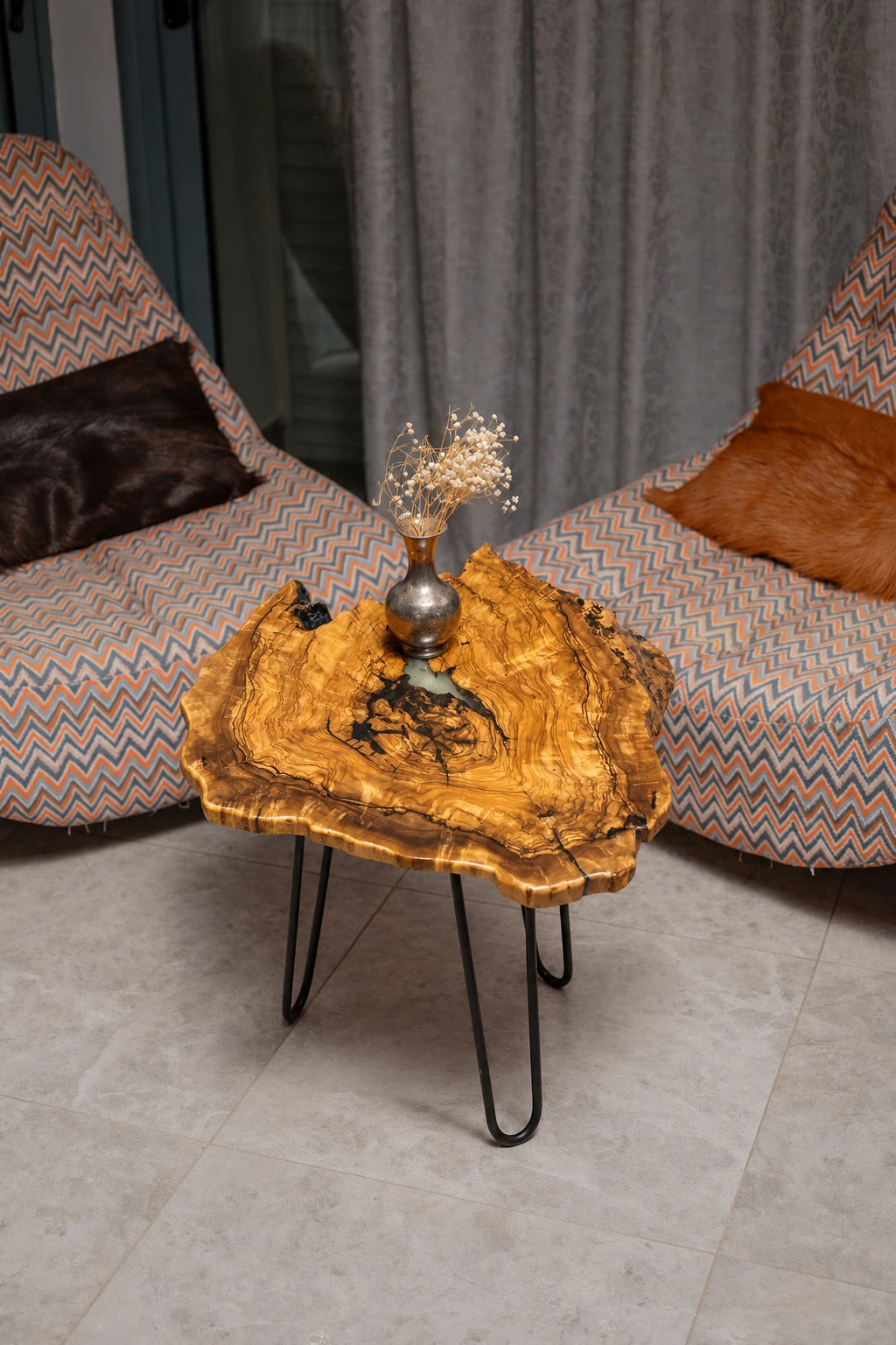 AI-styled view of Zitun Atelier table 074, an olive wood resin side table with black resin veins, viewed from above between two upholstered armchairs.