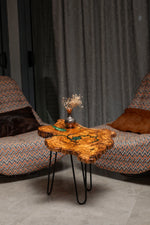 AI-styled view of Zitun Atelier table 075, an olive wood resin small coffee table with turquoise resin veins, in a lounge setting with a vase on the tabletop.