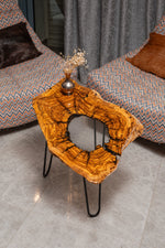 AI-styled view of Zitun Atelier table 076, an olive wood resin side table with white resin center, viewed from above between two upholstered armchairs.