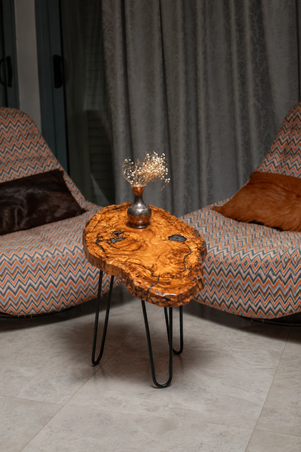 AI-styled view of Zitun Atelier table 077, an olive wood resin side table with black resin knots, in a lounge setting with a vase on the tabletop.